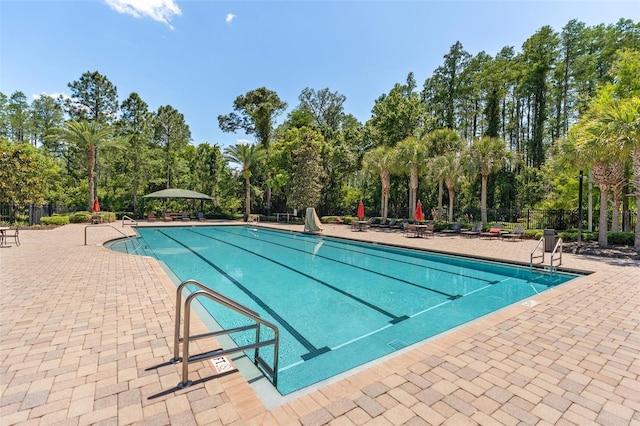pool featuring fence and a patio area