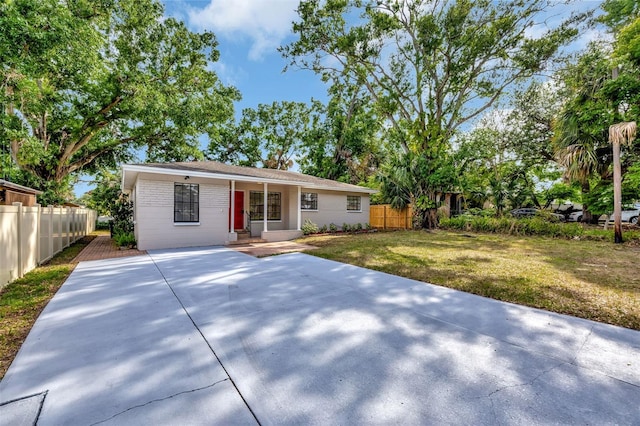 single story home with a front lawn and fence