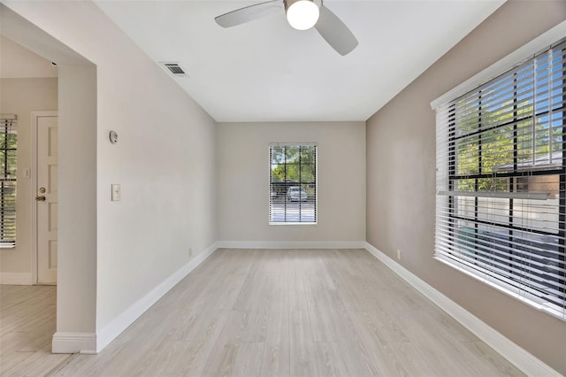 empty room featuring ceiling fan, baseboards, visible vents, and light wood finished floors