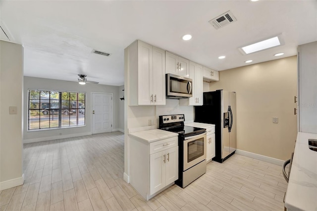 kitchen featuring baseboards, stainless steel appliances, and visible vents