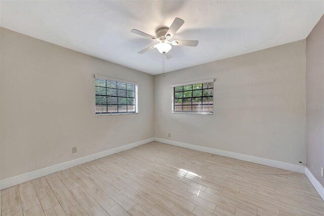 empty room with ceiling fan, baseboards, and light wood-type flooring