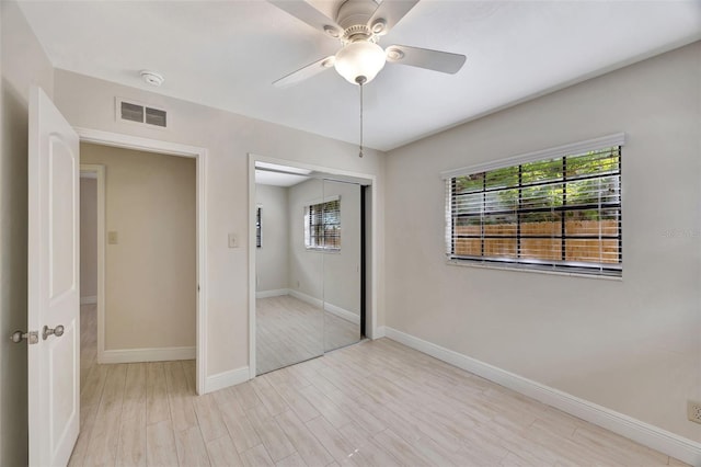 unfurnished bedroom with baseboards, multiple windows, visible vents, and a closet