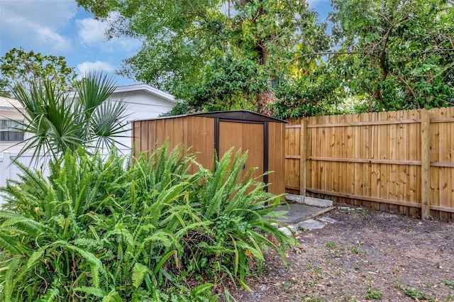 view of yard with a fenced backyard, an outdoor structure, and a shed
