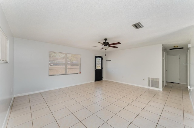 unfurnished room with light tile patterned flooring, visible vents, a ceiling fan, and a textured ceiling