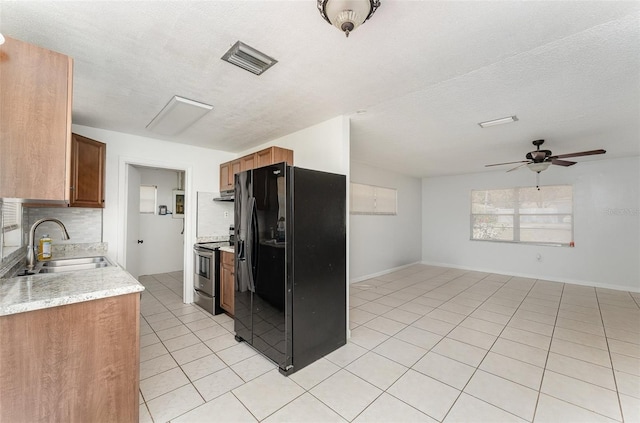 kitchen with light tile patterned floors, a sink, ceiling fan, black refrigerator with ice dispenser, and stainless steel electric range