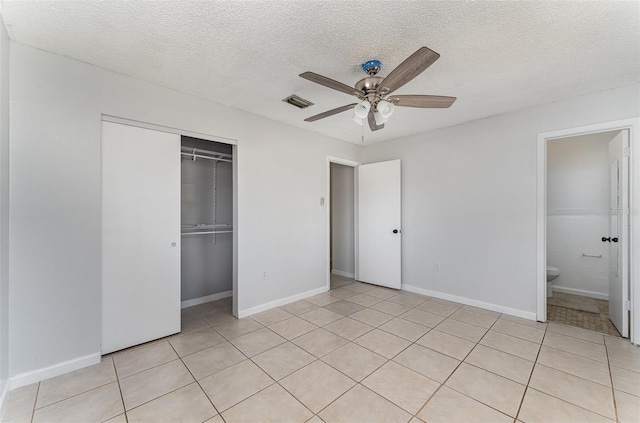 unfurnished bedroom featuring light tile patterned floors, a closet, ceiling fan, visible vents, and a textured ceiling
