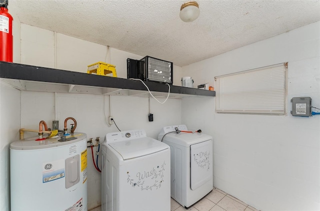 laundry area with light tile patterned flooring, laundry area, water heater, a textured ceiling, and washer and dryer
