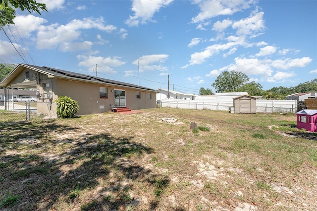 view of yard with a storage unit, an outbuilding, entry steps, and a fenced backyard