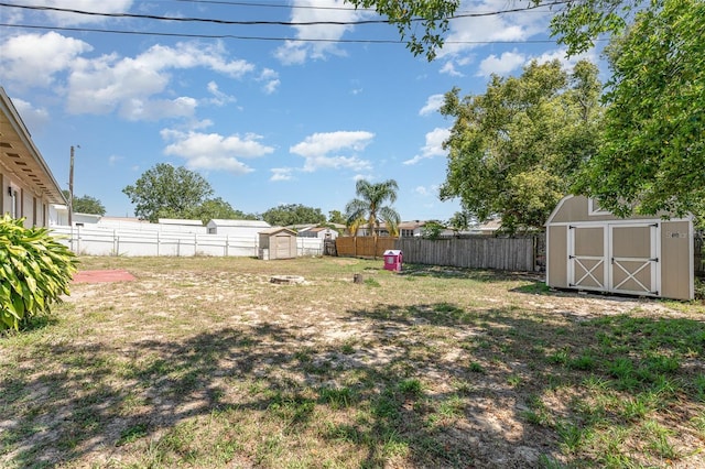 view of yard with a fenced backyard, a shed, and an outdoor structure