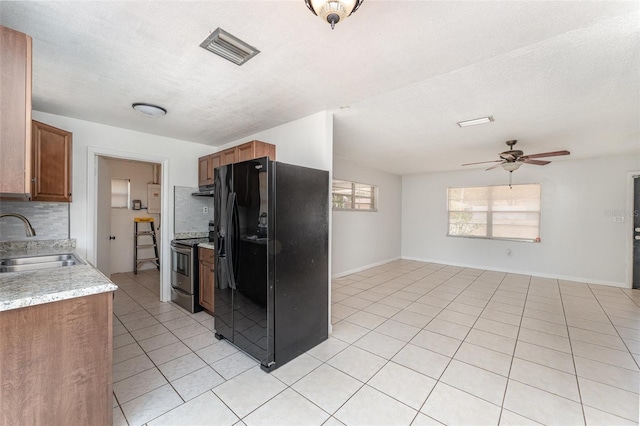 222 Aldo Dr, Babson Park, FL 33827 - kitchen featuring black fridge, a sink, electric range, tasteful backsplash, and light tile patterned floors