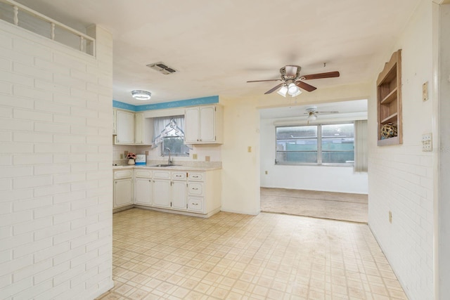 kitchen featuring light countertops, a ceiling fan, visible vents, and a sink
