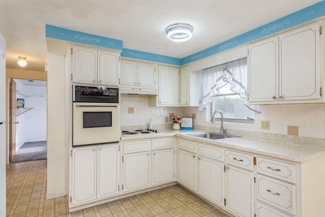 kitchen featuring white appliances, light countertops, a sink, and light floors
