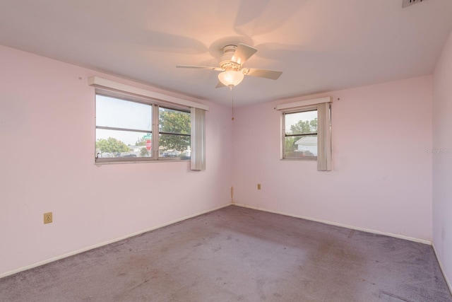 carpeted empty room with baseboards and a ceiling fan