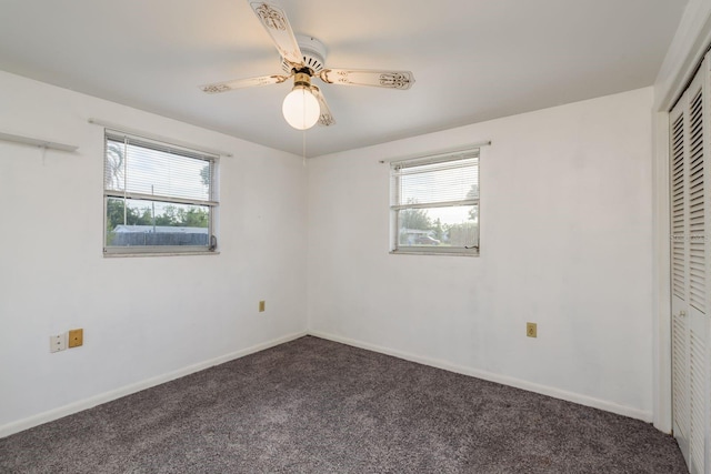 unfurnished bedroom with a closet, baseboards, multiple windows, and carpet flooring