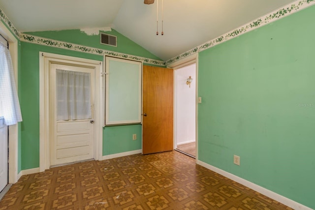 unfurnished room with baseboards, visible vents, and lofted ceiling