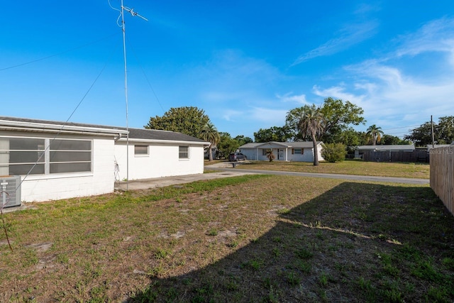view of yard featuring central air condition unit and fence