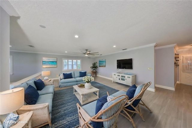 living area featuring baseboards, recessed lighting, wood finished floors, and crown molding