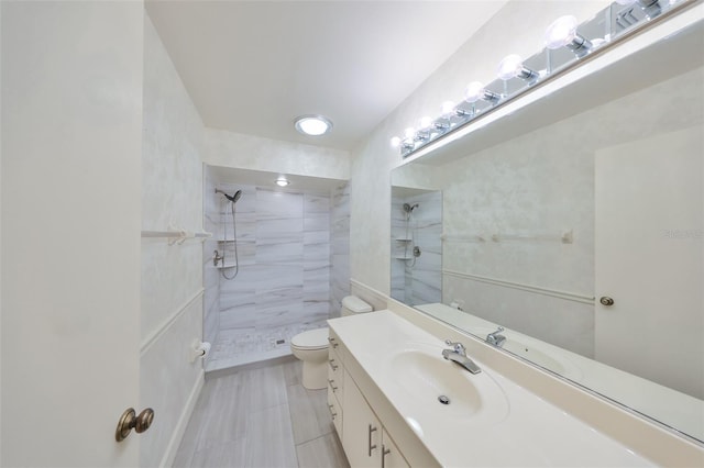 full bathroom featuring toilet, vanity, tile patterned floors, and a tile shower