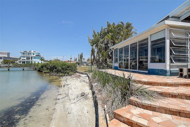 view of side of property with a water view and a sunroom