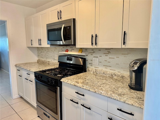 5501 80th St N Unit 509, Saint Petersburg, FL 33709 - kitchen featuring stainless steel appliances, light tile patterned floors, white cabinets, and tasteful backsplash