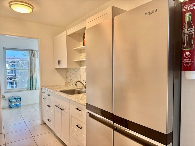 5501 80th St N Unit 509, Saint Petersburg, FL 33709 - kitchen featuring freestanding refrigerator, open shelves, backsplash, white cabinetry, and light tile patterned floors