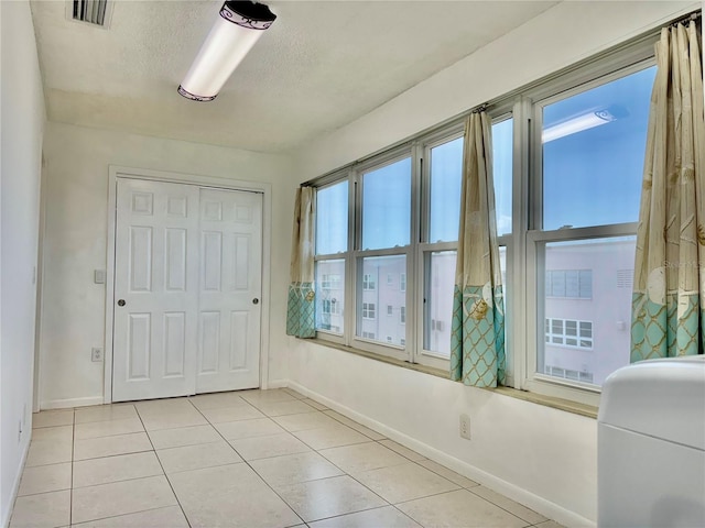 5501 80th St N Unit 509, Saint Petersburg, FL 33709 - bedroom with light tile patterned flooring, a textured ceiling, and a closet