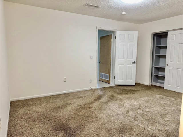 5501 80th St N Unit 509, Saint Petersburg, FL 33709 - unfurnished bedroom featuring carpet flooring, a textured ceiling, and a closet