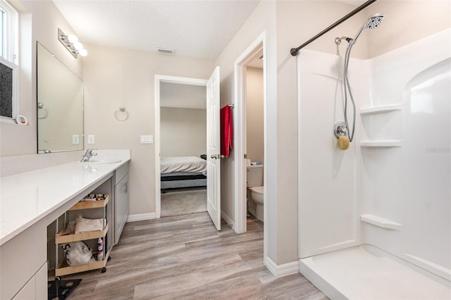 1646 Seth Dr, Winter Haven, FL 33880 - ensuite bathroom with wood finished floors, vanity, toilet, and a stall shower