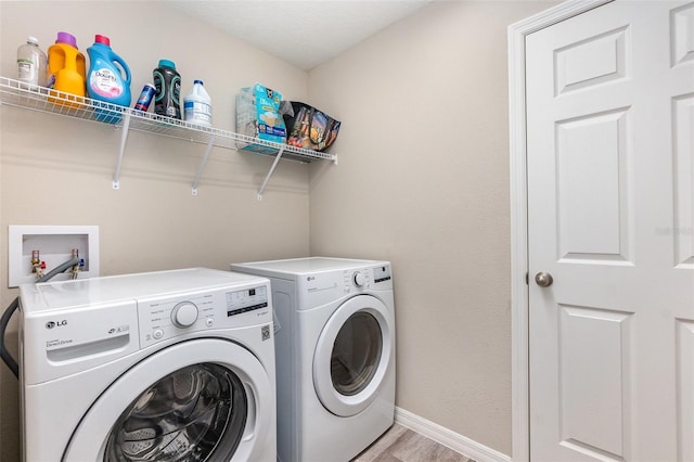 1646 Seth Dr, Winter Haven, FL 33880 - washroom featuring washing machine and dryer, light wood-style floors, baseboards, and laundry area