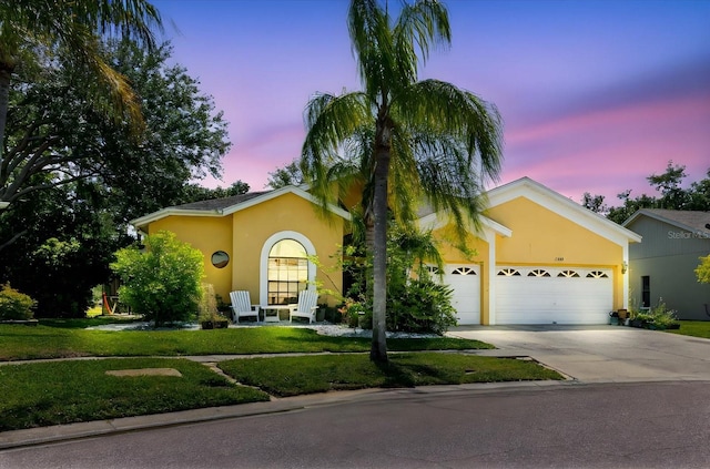 11209 Pocket Brook Dr, Tampa, FL 33635 - view of front of property with an attached garage, concrete driveway, stucco siding, and a lawn