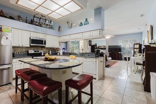 11209 Pocket Brook Dr, Tampa, FL 33635 - kitchen featuring stainless steel appliances, tasteful backsplash, plenty of natural light, dark countertops, and visible vents