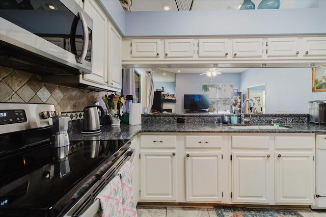 11209 Pocket Brook Dr, Tampa, FL 33635 - kitchen with white cabinets, stainless steel appliances, a sink, dark stone counters, and a ceiling fan