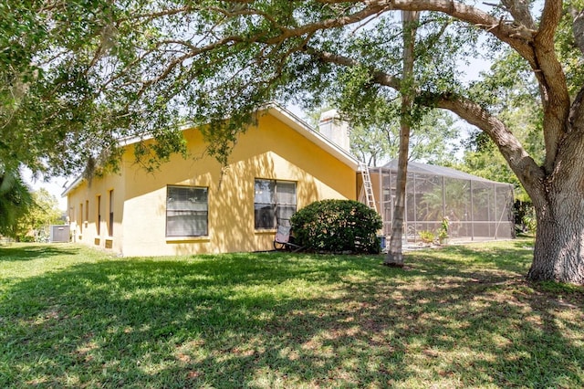 11209 Pocket Brook Dr, Tampa, FL 33635 - view of home's exterior featuring glass enclosure, a yard, and stucco siding