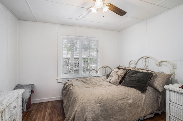 bedroom featuring baseboards, a ceiling fan, and dark wood finished floors