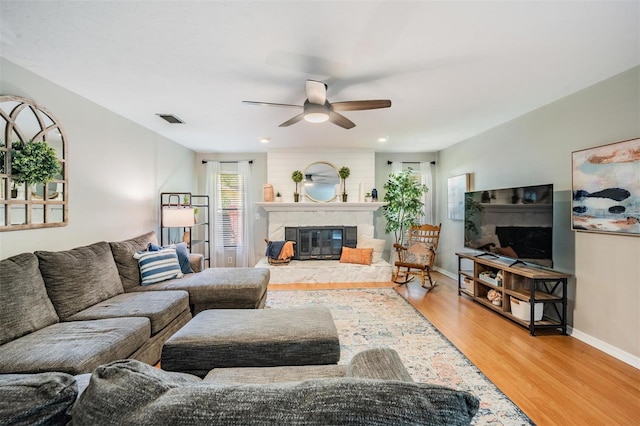 34 Hickory Ln, Safety Harbor, FL 34695 - living room featuring baseboards, a glass covered fireplace, visible vents, a ceiling fan, and wood finished floors