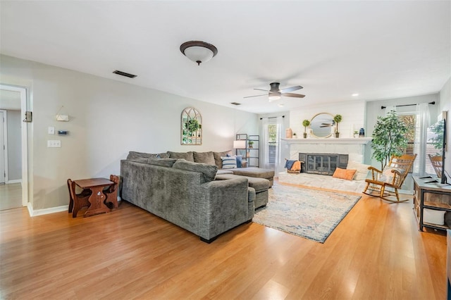 34 Hickory Ln, Safety Harbor, FL 34695 - living area featuring visible vents, light wood-type flooring, baseboards, a fireplace, and ceiling fan
