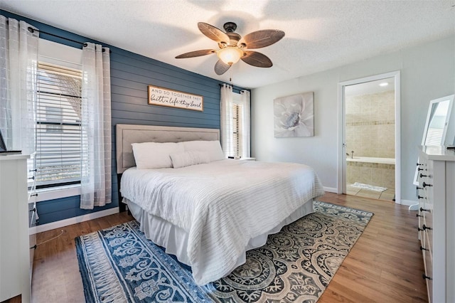 34 Hickory Ln, Safety Harbor, FL 34695 - bedroom with connected bathroom, wood finished floors, multiple windows, and a textured ceiling