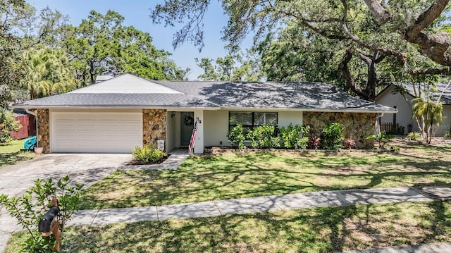 34 Hickory Ln, Safety Harbor, FL 34695 - ranch-style house with a garage, stone siding, a front yard, and concrete driveway