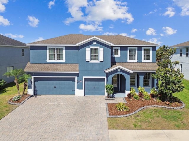 11852 Lake Lucaya Dr, Riverview, FL 33579 - traditional home featuring a shingled roof, stucco siding, an attached garage, and decorative driveway