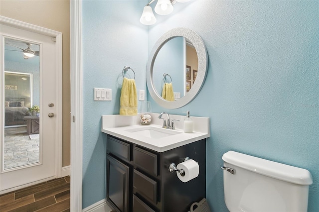 11852 Lake Lucaya Dr, Riverview, FL 33579 - bathroom with vanity, toilet, baseboards, wood tiled floor, and a ceiling fan