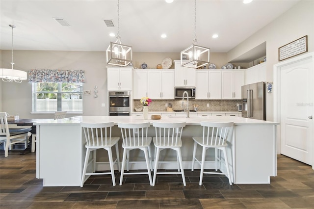 11852 Lake Lucaya Dr, Riverview, FL 33579 - kitchen with visible vents, light countertops, backsplash, and stainless steel appliances