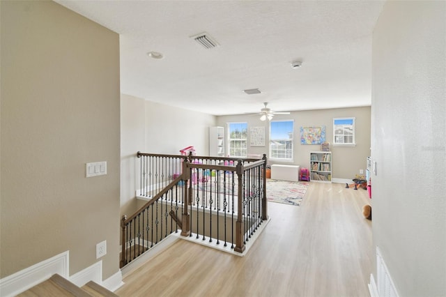 11852 Lake Lucaya Dr, Riverview, FL 33579 - hall with visible vents, baseboards, wood finished floors, and an upstairs landing