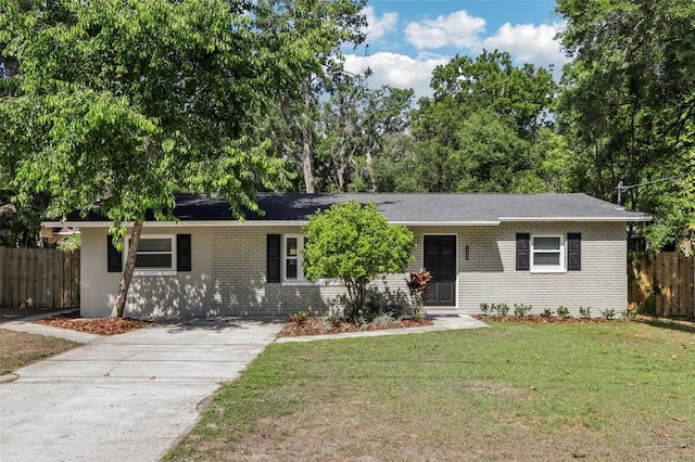 ranch-style house with fence, a front lawn, driveway, and brick siding