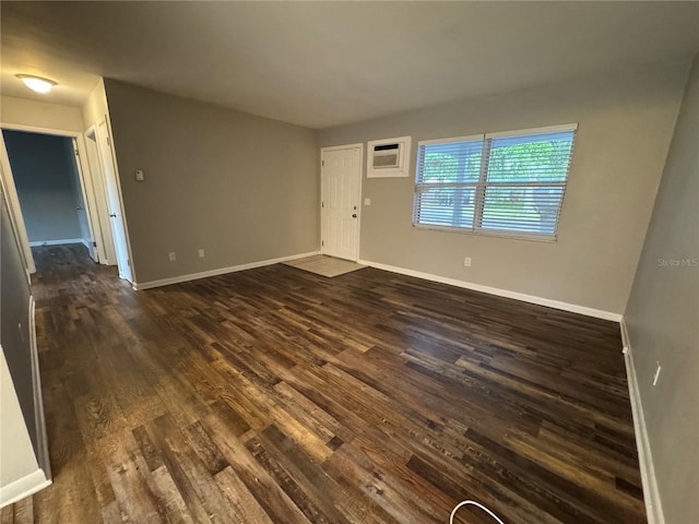 766 Beltrees St, Dunedin, FL 34698 - unfurnished living room with dark wood-type flooring, baseboards, and a wall mounted air conditioner