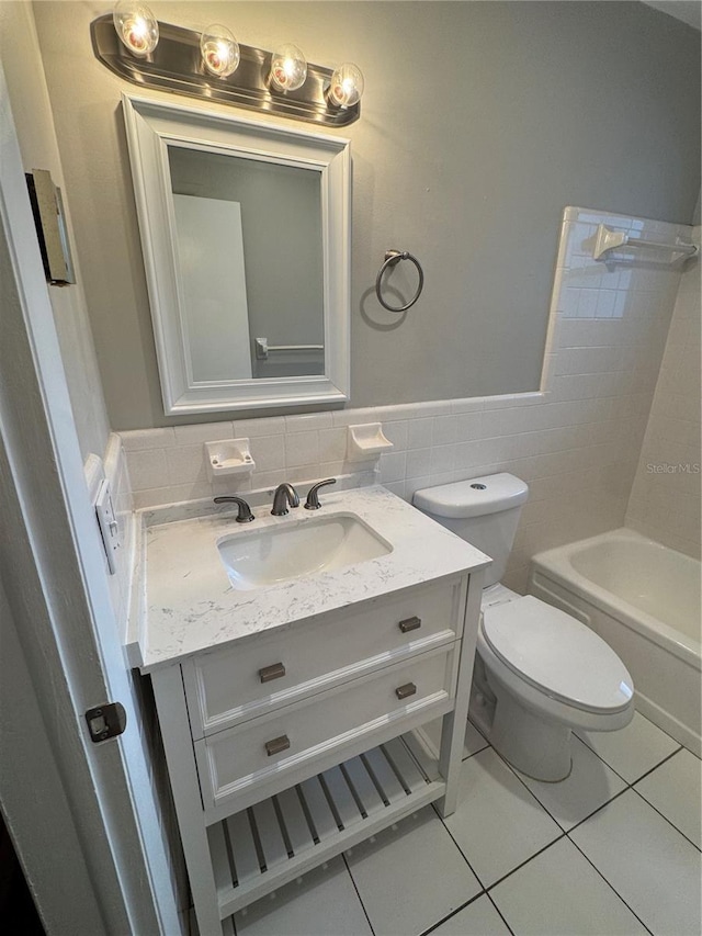 766 Beltrees St, Dunedin, FL 34698 - bathroom with vanity, tile patterned flooring, tile walls, toilet, and wainscoting