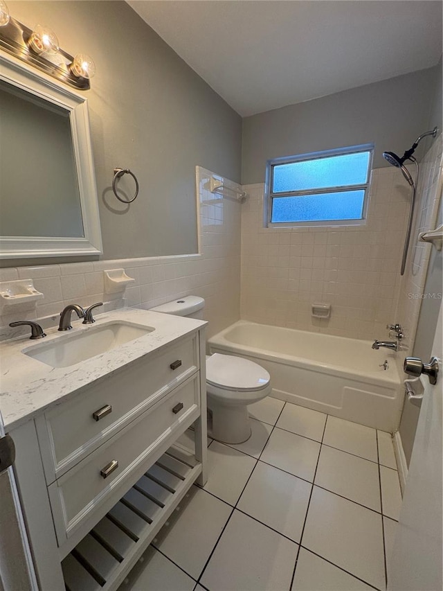 766 Beltrees St, Dunedin, FL 34698 - bathroom featuring tile patterned flooring, toilet, vanity, washtub / shower combination, and tile walls