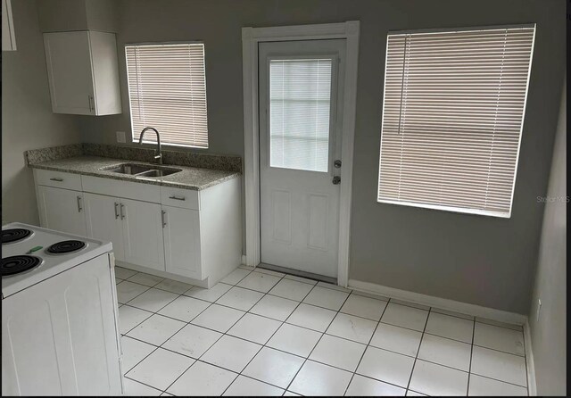 766 Beltrees St, Dunedin, FL 34698 - kitchen with a sink, electric range, white cabinets, light countertops, and baseboards