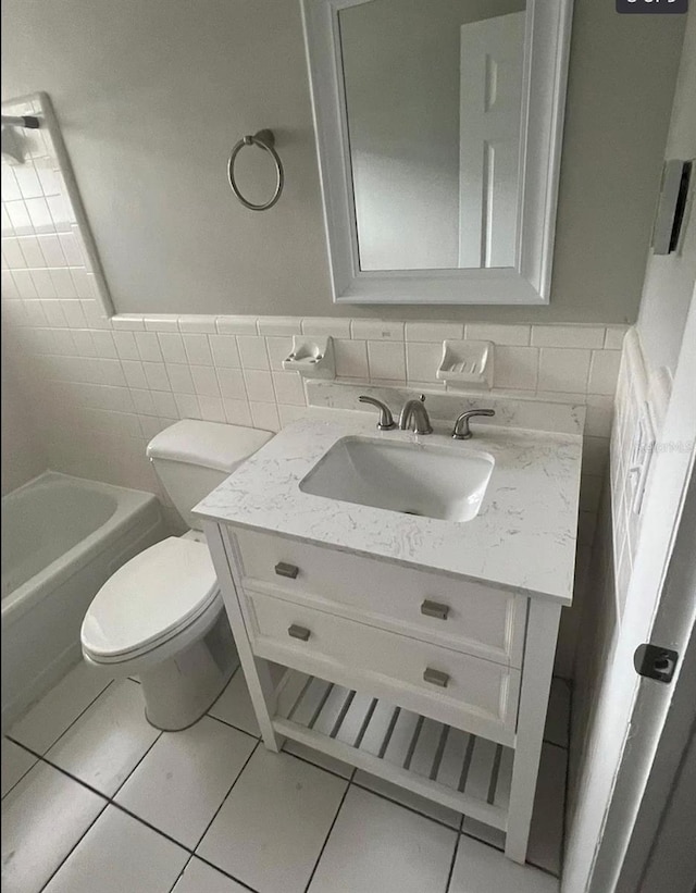 766 Beltrees St, Dunedin, FL 34698 - bathroom with tile walls, vanity, tile patterned floors, toilet, and a wainscoted wall
