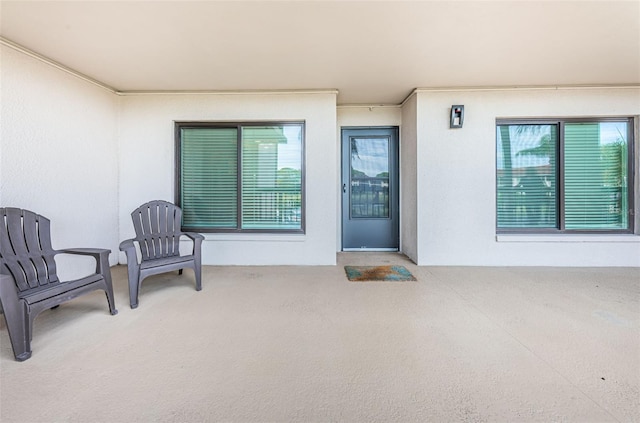 doorway to property with a patio area and stucco siding