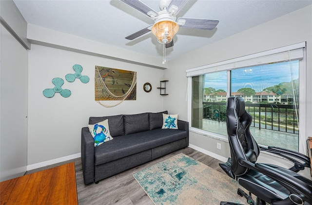 office featuring baseboards, a ceiling fan, and wood finished floors